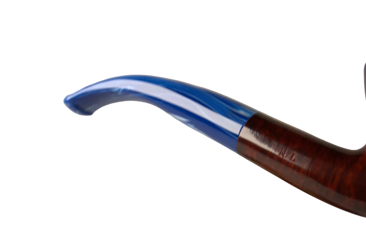 A close-up of a smoking pipe with a glossy dark brown wood body and a curved blue glass bowl, resting above a polished wooden holder against a neutral gray background.