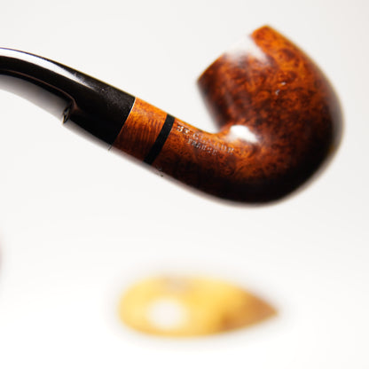 Close-up of a brown pipe with a black band on a white background