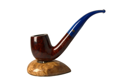 A smoking pipe with a glossy dark reddish-brown body and a curved blue stem, displayed on a carved wooden stand against a neutral gray background.