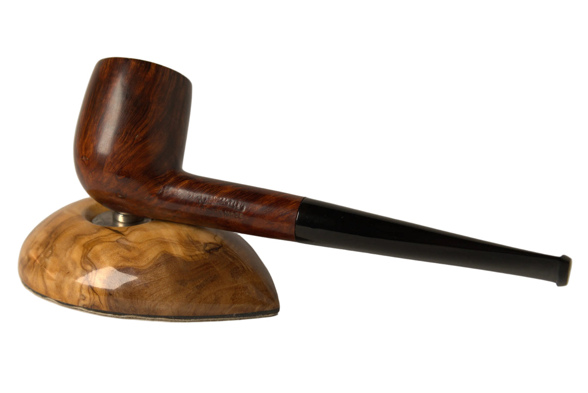 A smoking pipe with a dark brown wood bowl and a black stem, displayed on a matching carved wooden stand against a neutral gray background.