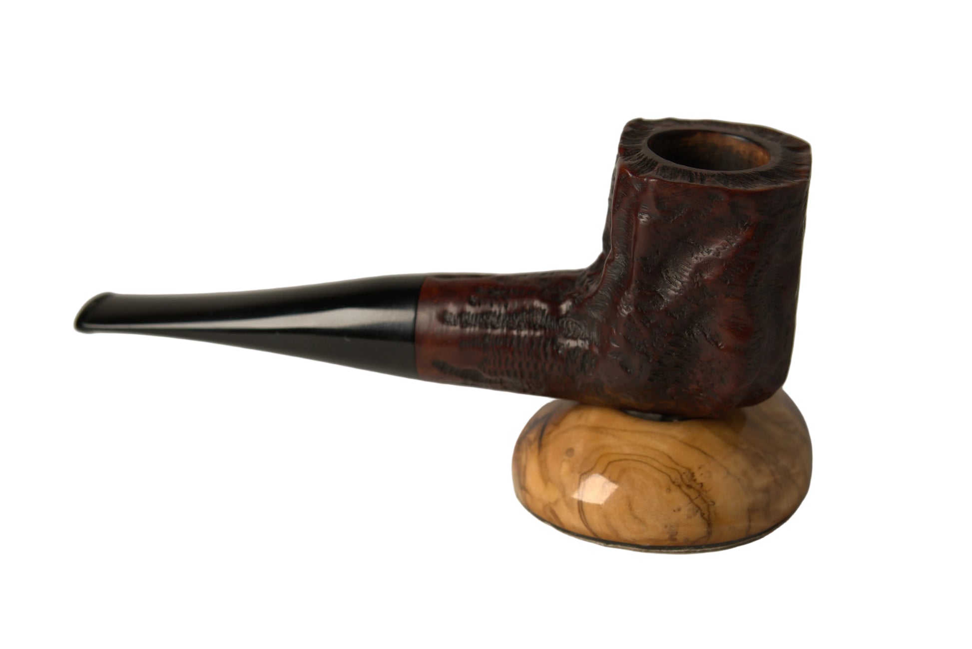 A dark brown carved smoking pipe with a glossy black stem, displayed on a polished light brown wooden stand against a neutral gray background.