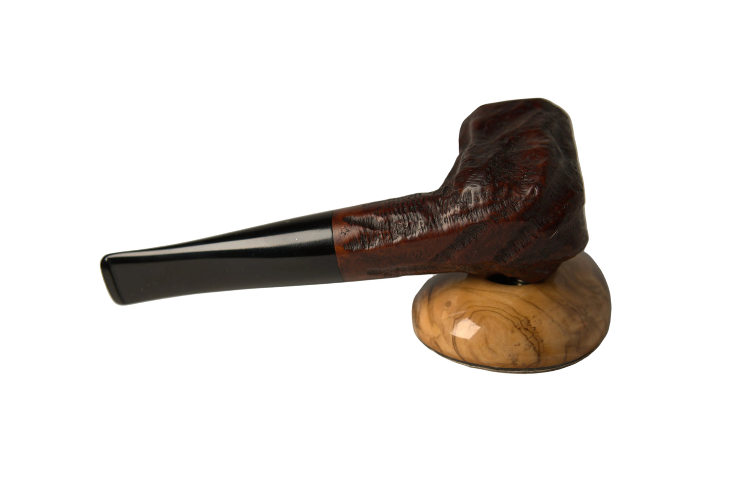 A smoking pipe with a dark reddish-brown carved bowl and a glossy black stem, displayed on a polished light wood stand against a neutral gray background.
