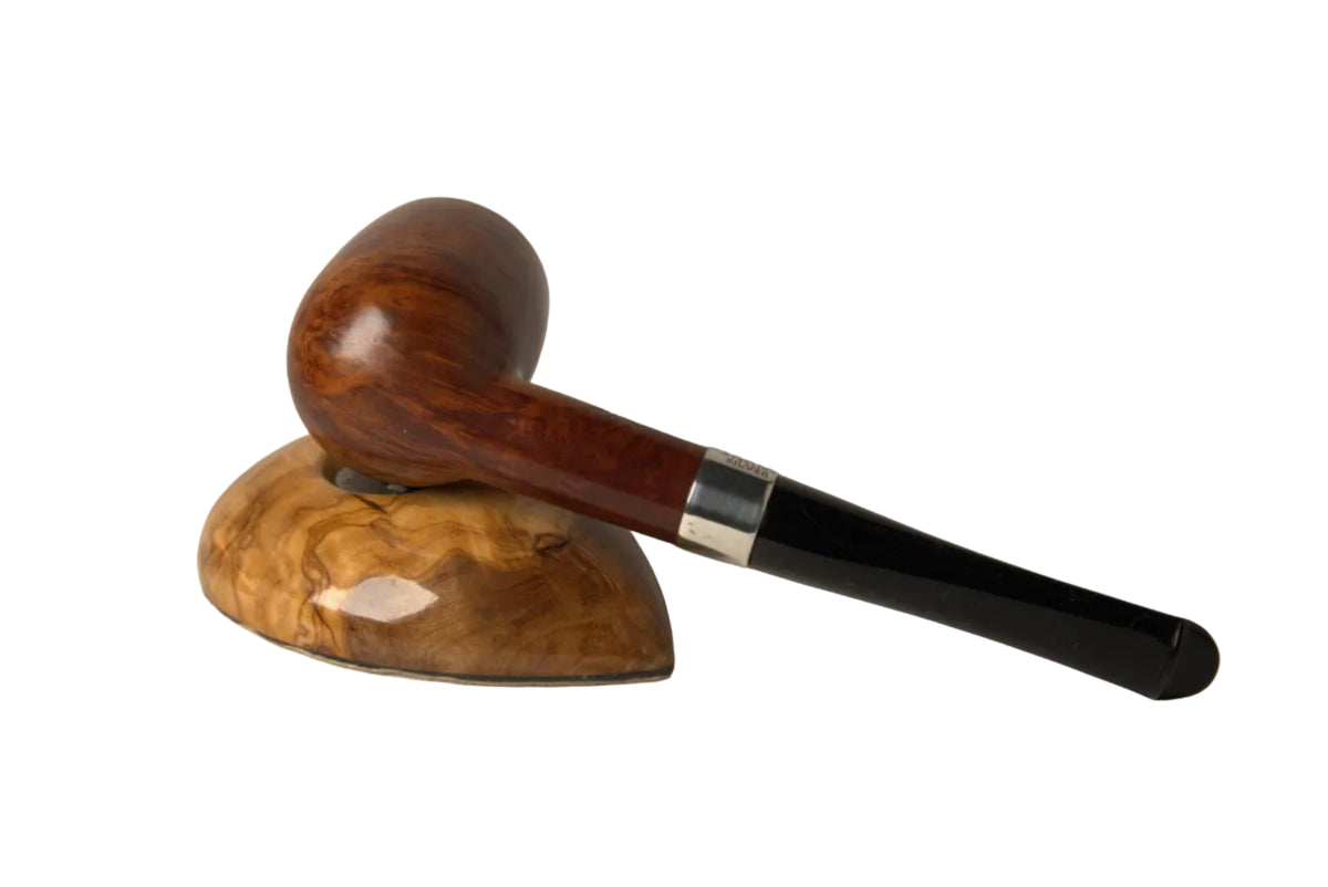 A polished wooden smoking pipe with a dark black handle and silver ferrule, resting on a matching carved wooden stand against a neutral light gray background.