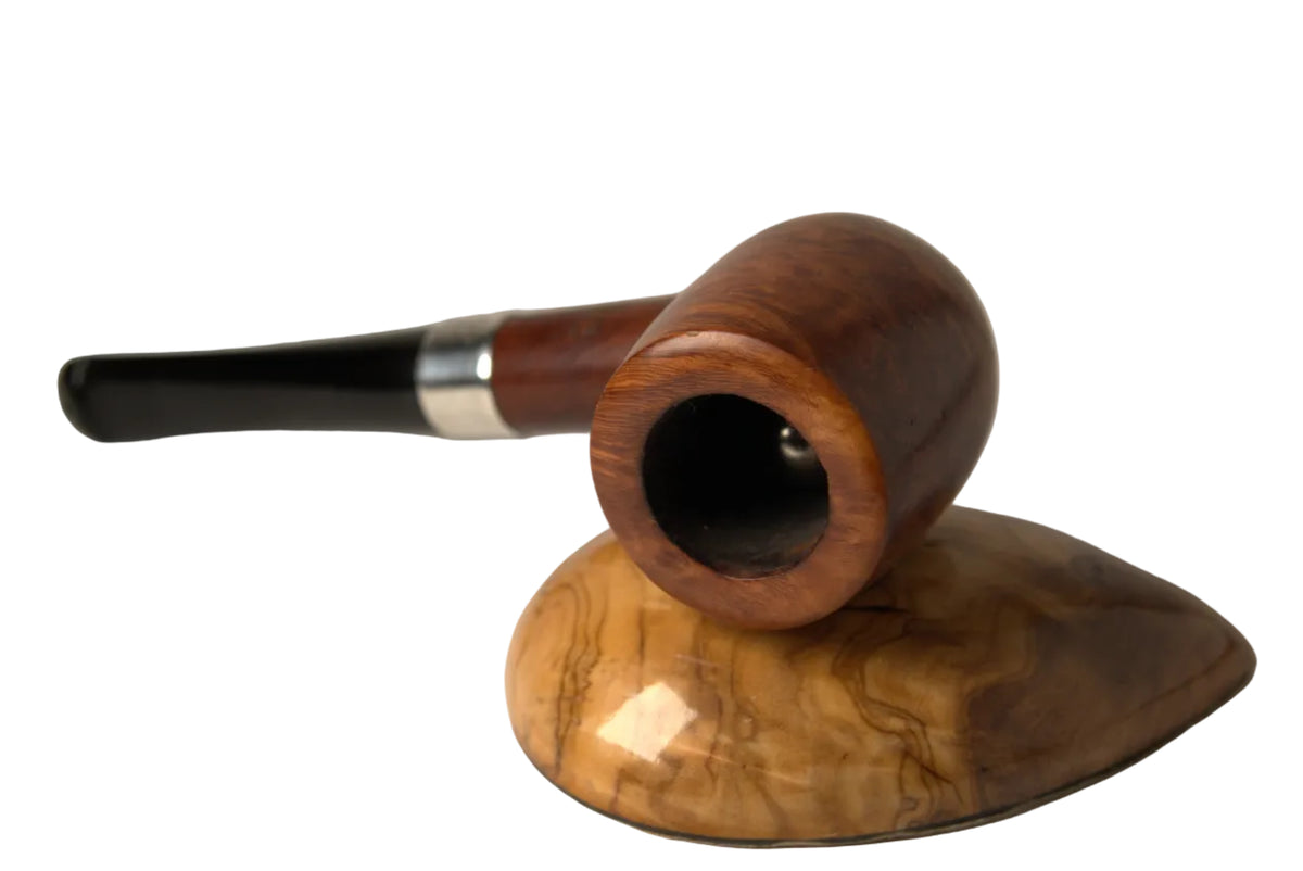 A wooden smoking pipe with a polished brown bowl and a black stem, resting on a matching carved wooden stand against a neutral light gray background.