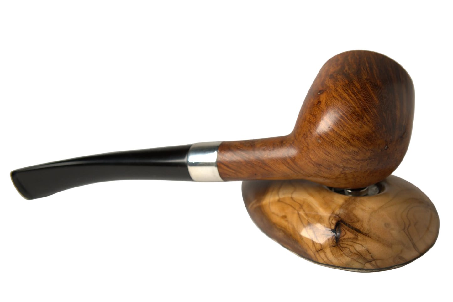 A smoking pipe with a polished brown wooden bowl and a black stem with a silver band, resting on a matching carved wooden stand against a neutral gray background.