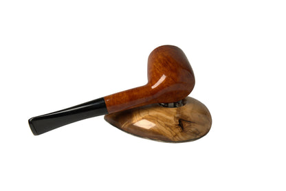 A polished wooden smoking pipe with a glossy brown bowl and black stem, resting on a matching carved wooden stand against a neutral gray background.