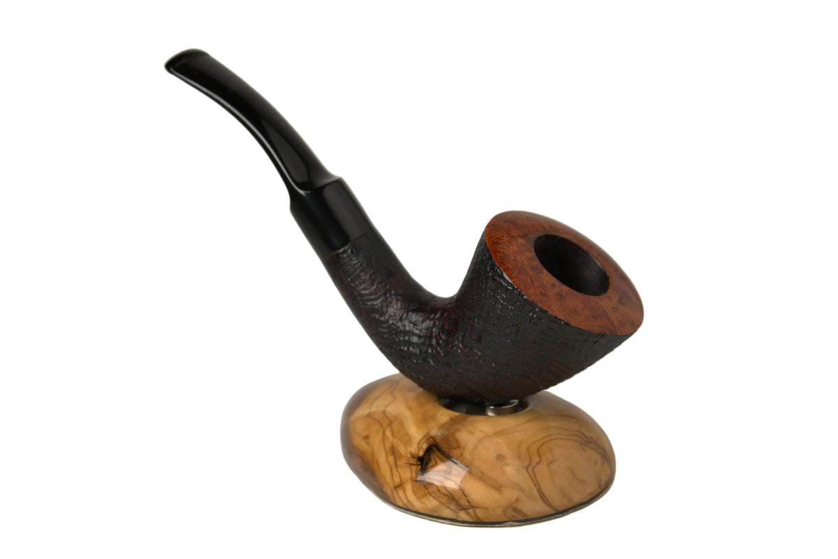 A smoking pipe with a dark textured stem and a warm brown bowl, displayed on a polished wooden stand against a neutral gray studio background.