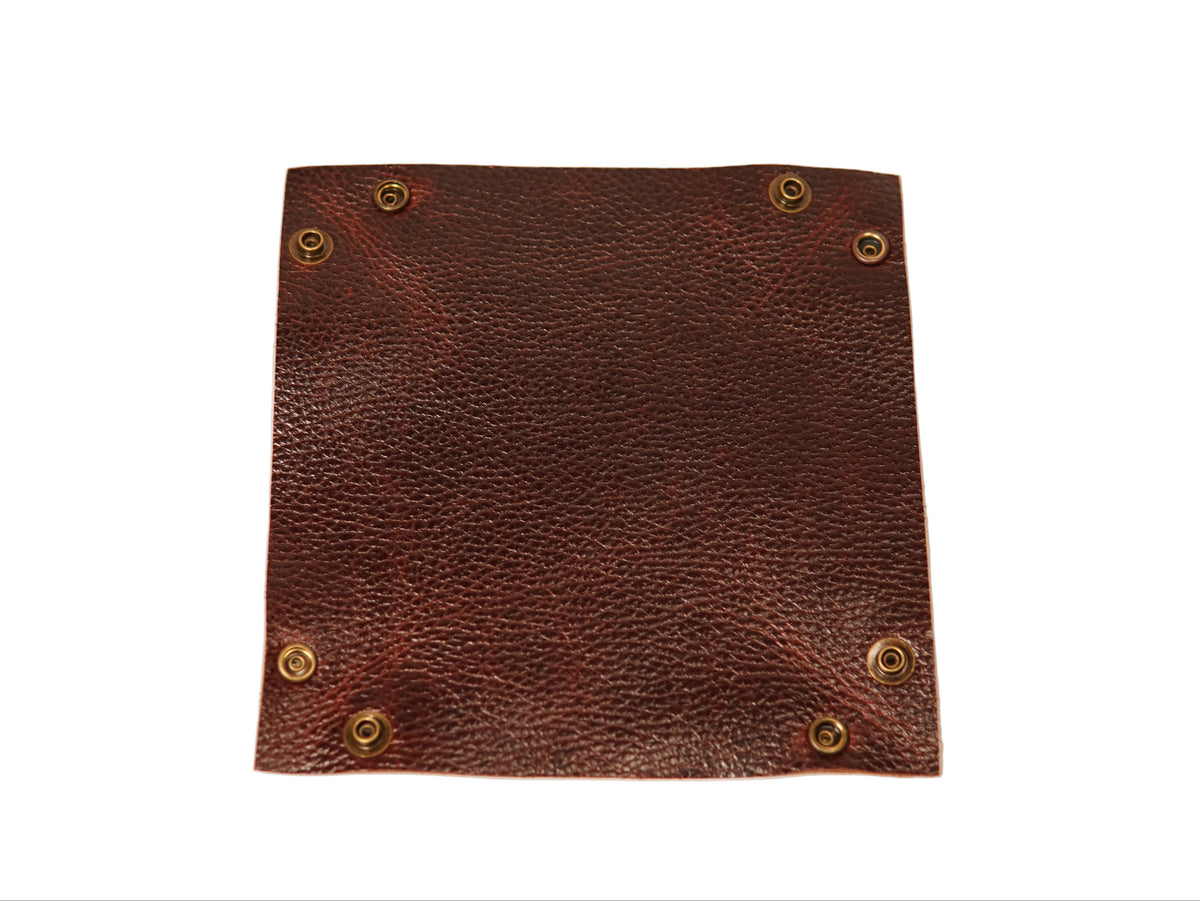 A square brown textured leather patch with brass grommets in the corners, shown on a plain white background.