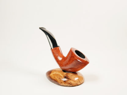 A smoking pipe with a glossy reddish-brown wood body and a curved black stem, displayed on a matching polished wood base against a plain white background.