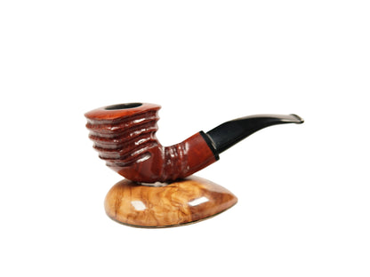 A smoking pipe with a ribbed reddish-brown bowl and a curved black stem, displayed on a polished wood stand against a plain white background.