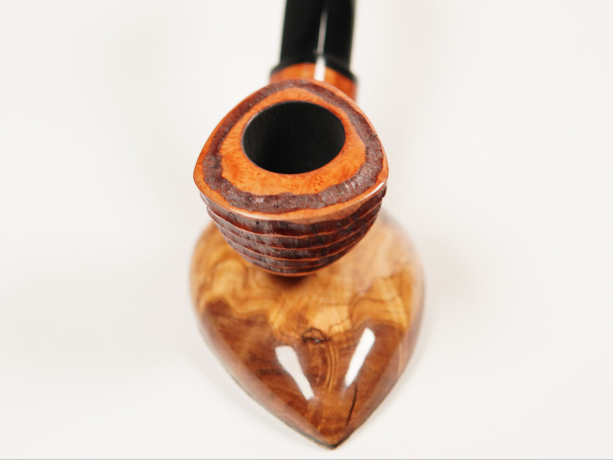 A handcrafted smoking pipe with a polished, wavy brown wood bowl and a black stem, photographed on a seamless white background.