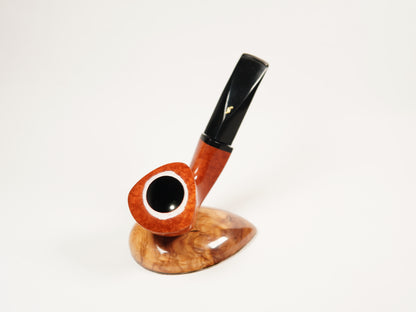 A smoking pipe with a polished orange-brown wood bowl, black stem, and matching wooden base, photographed on a clean white background.
