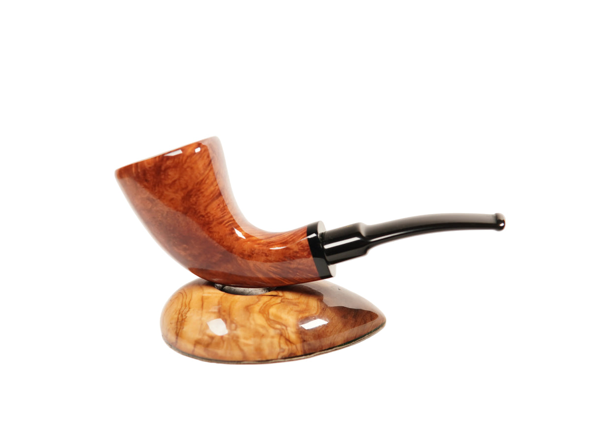 A polished smoking pipe with a curved reddish-brown wood bowl and a dark stem, displayed on a matching carved wooden stand against a clean white background.