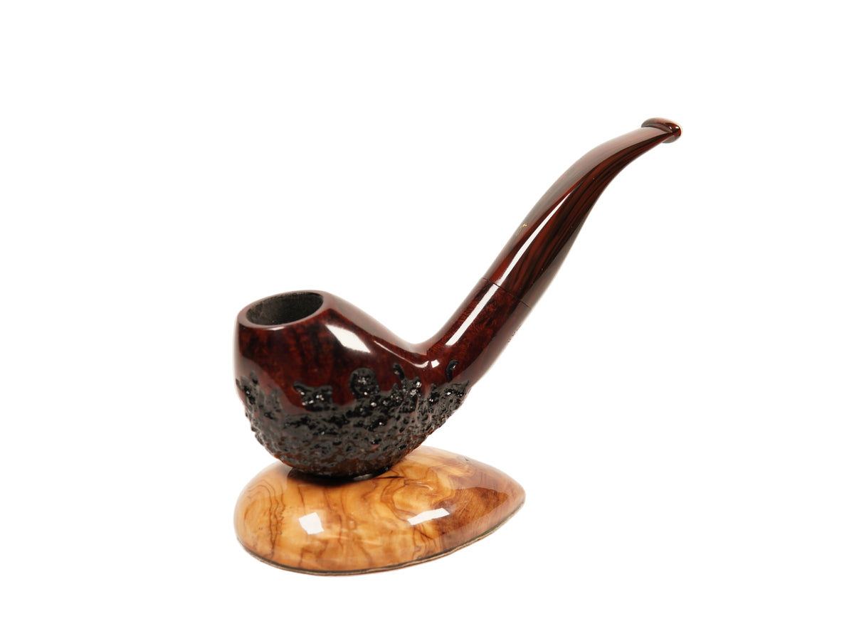 A decorative smoking pipe with a glossy dark reddish-brown body and a curved wooden base, photographed on a clean white studio background.