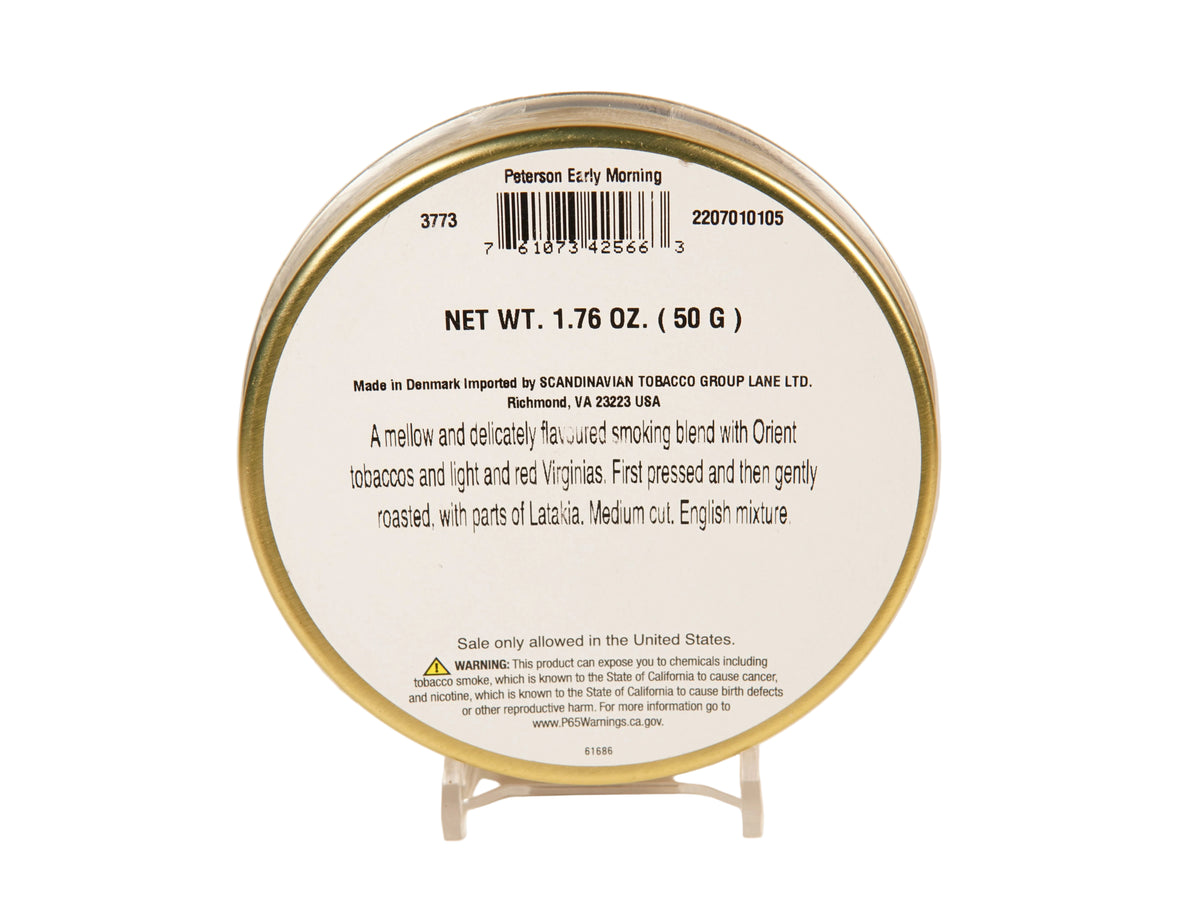 Back side of a round tobacco product tin on a small clear display stand, with printed text and barcode visible against a plain light background.
