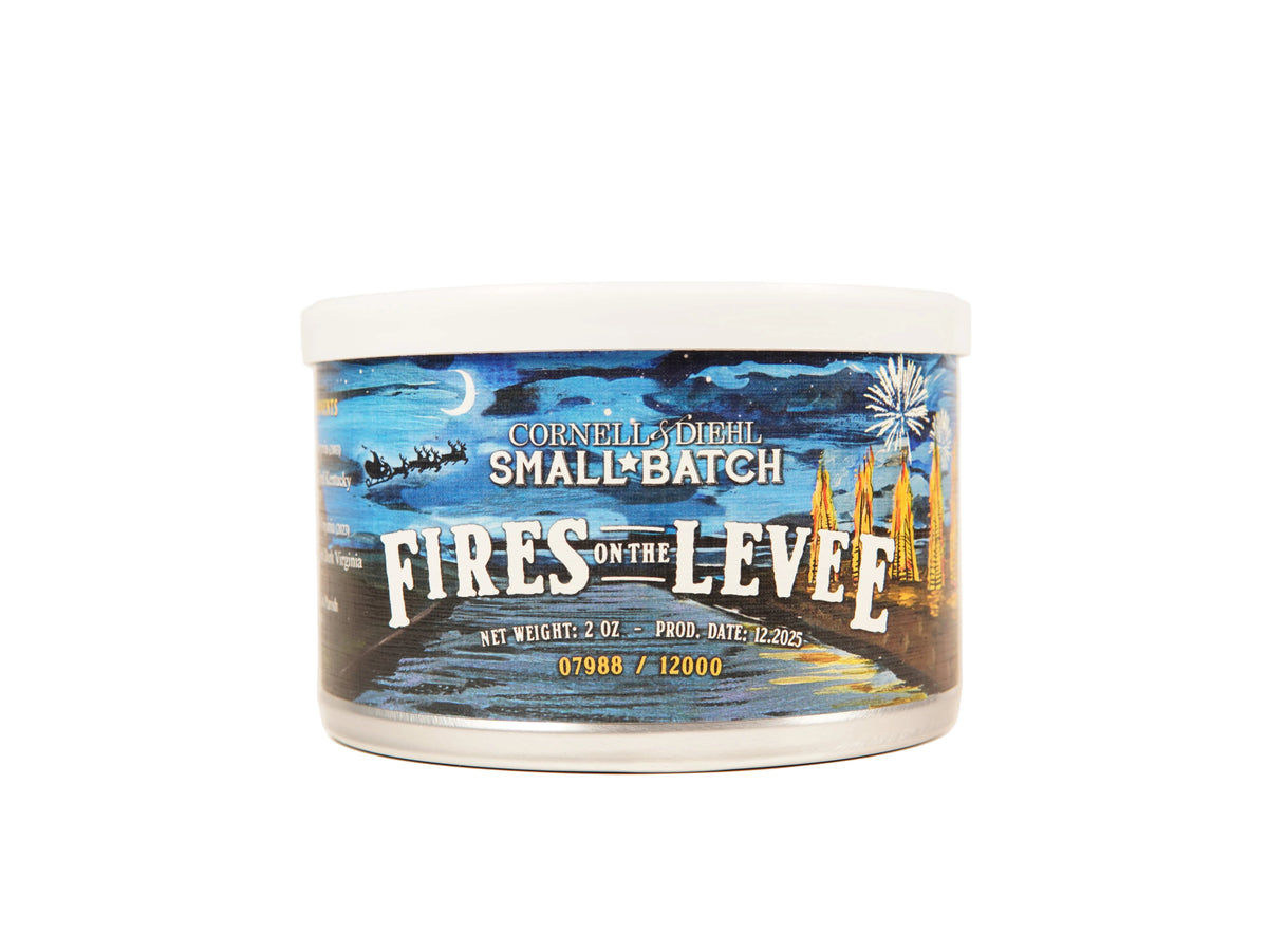 Cornell's Dream Small Batch Fires on the Levee candle in a 2 oz white plastic jar with a detailed label depicting a nighttime harbor scene with fireworks.